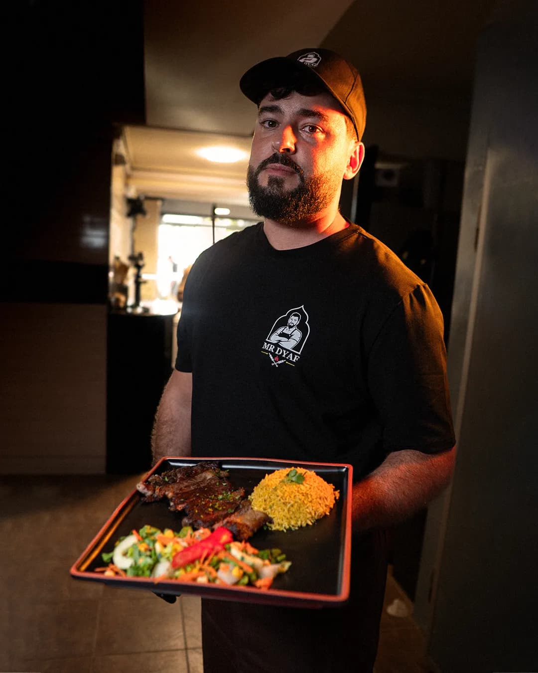 Mr Dyaf server bringing a plate of grilled ribs and rice